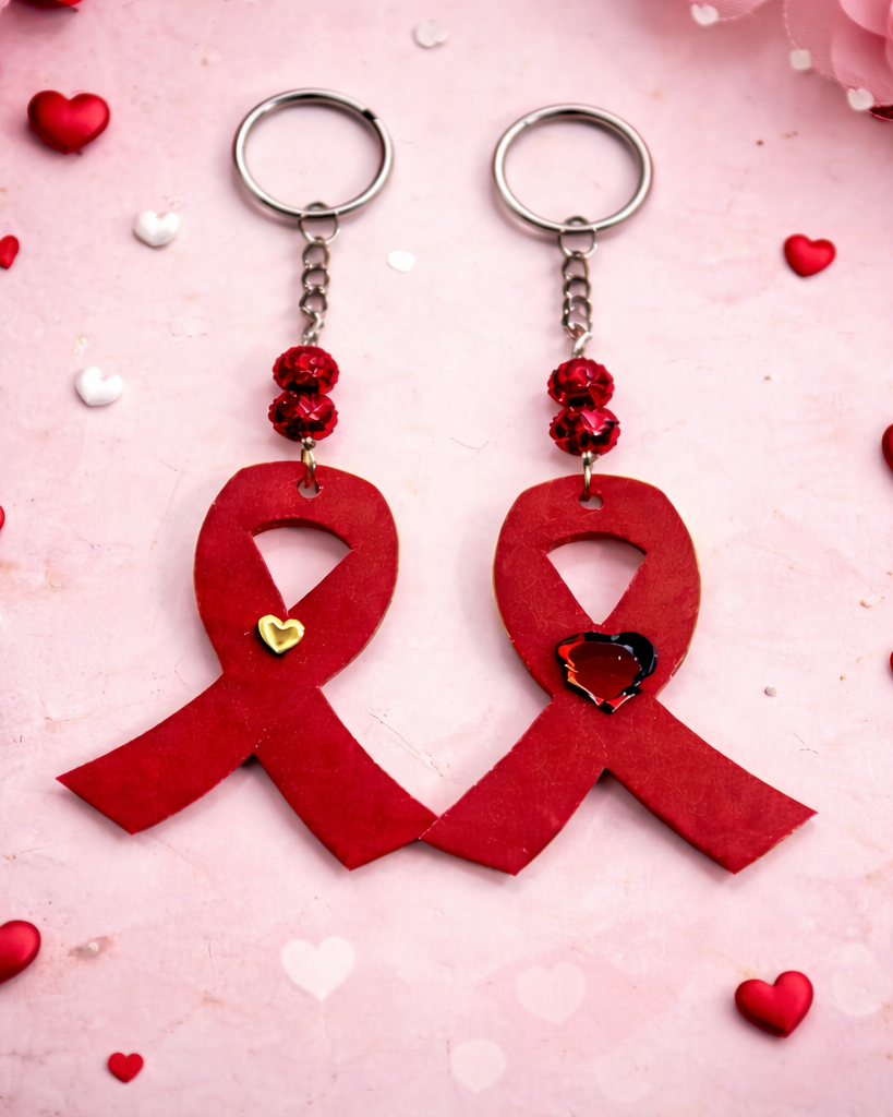 Two red ribbon keychains with heart details on a pink background with hearts.