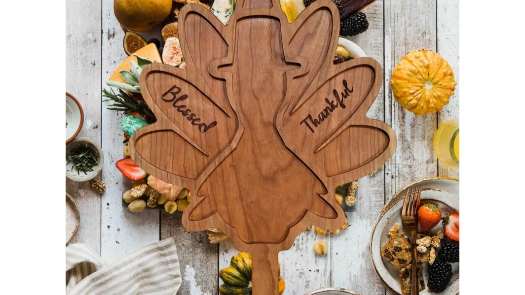 A wooden turkey with the words " blessed thankful " carved into it.