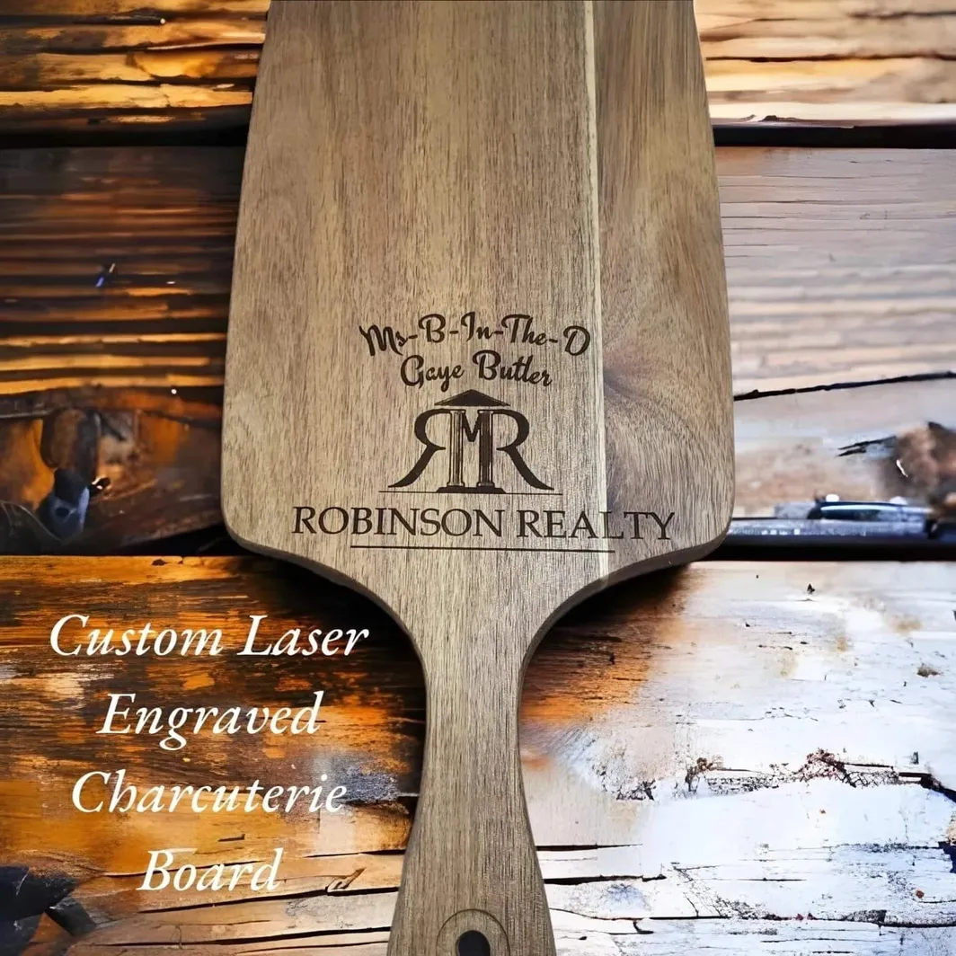 A wooden paddle with the name robinson realty engraved on it.