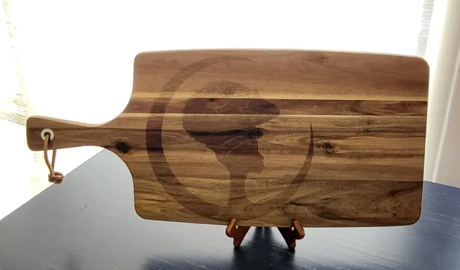 A wooden cutting board with an image of the silhouette of a person.