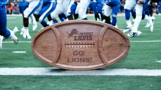 A wooden football with the detroit lions logo on it.